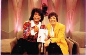 Suzy and Oprah with a book on a couch